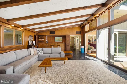 a living room with furniture a fireplace and large windows