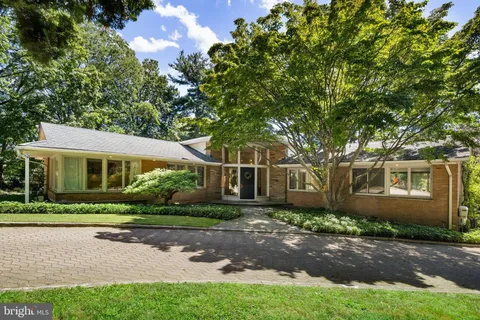a front view of a house with yard and green space