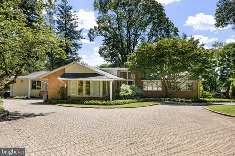 a front view of a house with a yard and trees