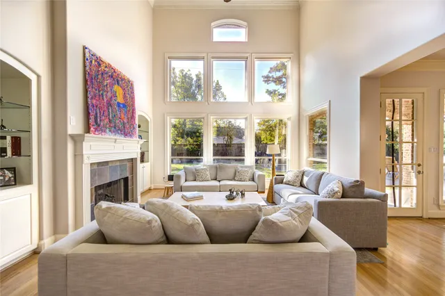 a living room with furniture fireplace and large windows