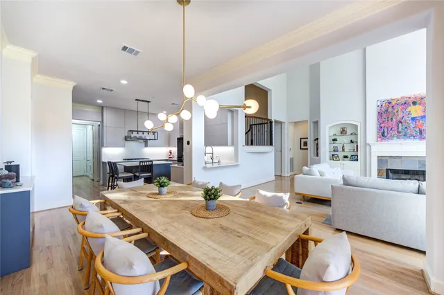 a view of a dining room and livingroom with furniture wooden floor a rug and a chandelier