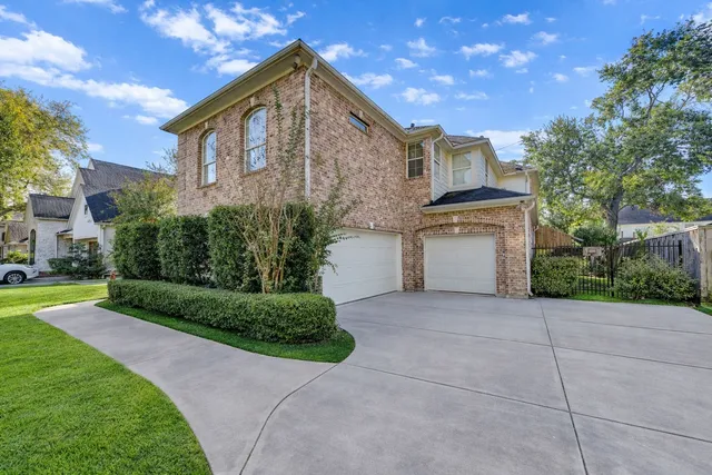 a front view of a house with a garden and trees