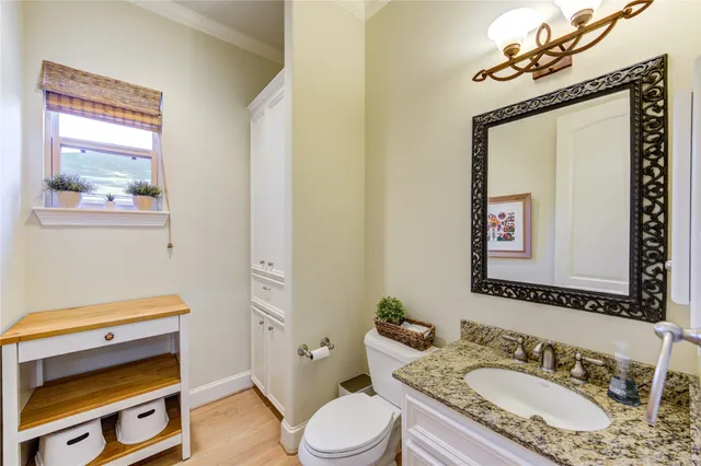 a bathroom with a granite countertop toilet sink and mirror