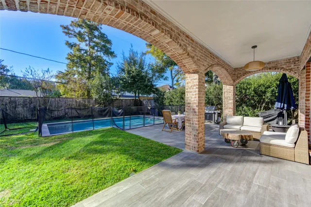 a view of a patio with couches and a table and chairs with plants and garden