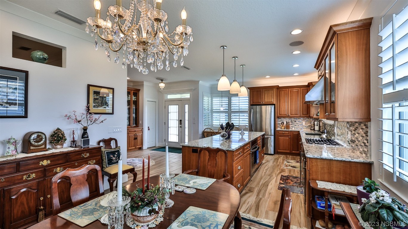 606 Midfield Loop Edgewater, FL 32132 - Photo 16 of 42 a view of a dining room with furniture a chandelier and large windows