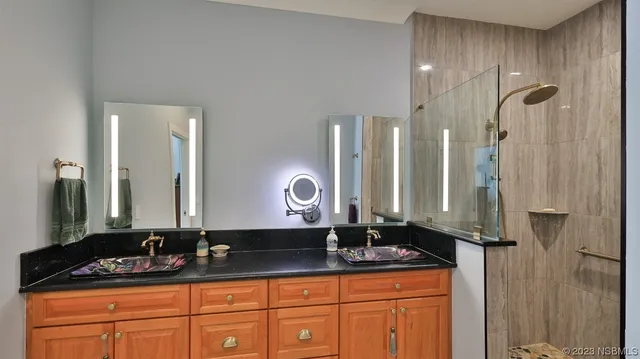 a bathroom with double sink and a mirror