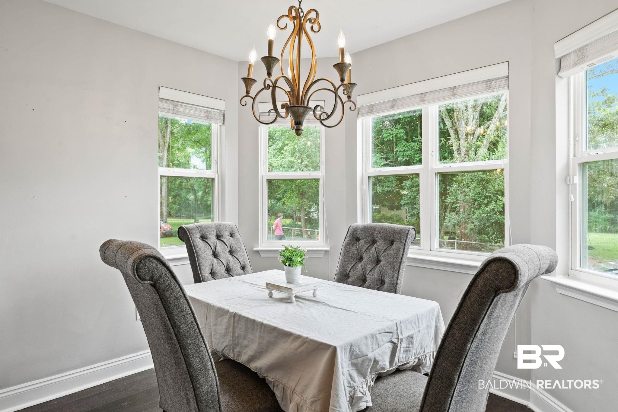 22810 High Ridge Road Fairhope, AL 36532 - Photo 24 of 78 Dining area featuring a bronze-finish chandelier, multiple windows with natural light, dark wood-finish flooring, and white baseboards