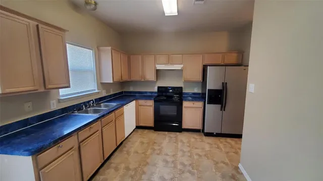 a kitchen with stainless steel appliances a refrigerator and a sink