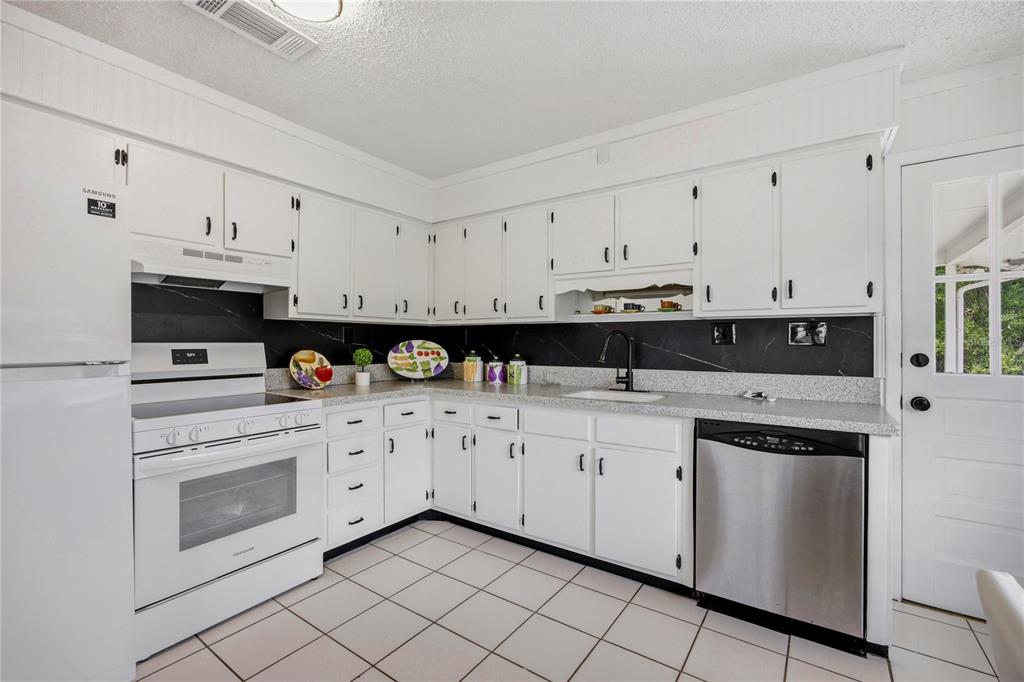 113 Browns Road San Mateo, FL 32187 - Photo 17 of 36 a kitchen with stainless steel appliances granite countertop white cabinets and sink