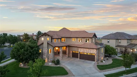a front view of a house with a yard and potted plants
