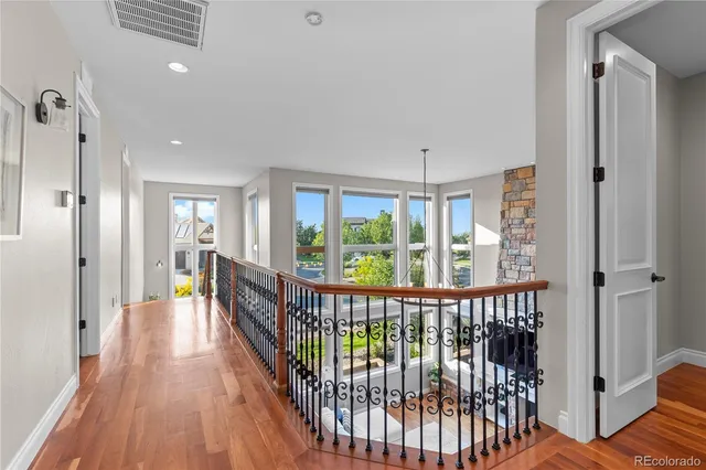a view of a hallway with wooden floor and windows