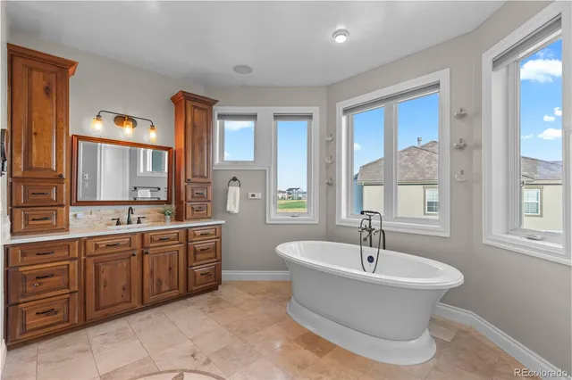 a bathroom with a tub sink and mirror