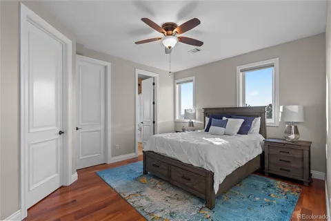 a bedroom with a bed and a table with wooden floor
