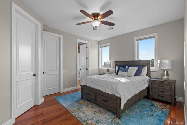 a bedroom with a bed and a table with wooden floor