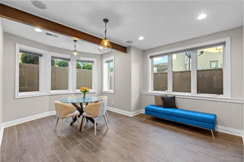 a dining room with wooden floor and a potted plant