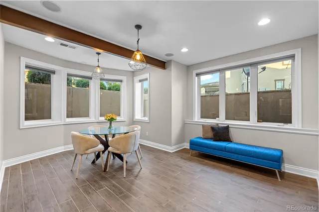 a dining room with wooden floor and a potted plant