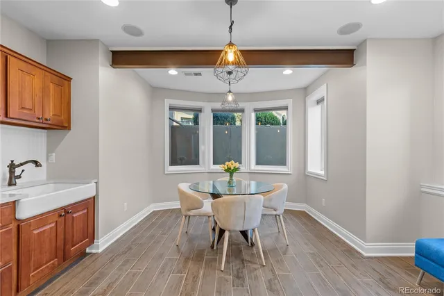 a dining room with wooden floor a chandelier a wooden table and chairs