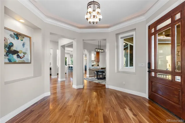 a view of a livingroom with wooden floor and a chandelier