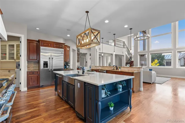 a large kitchen with kitchen island a stove a sink a refrigerator and a living room view