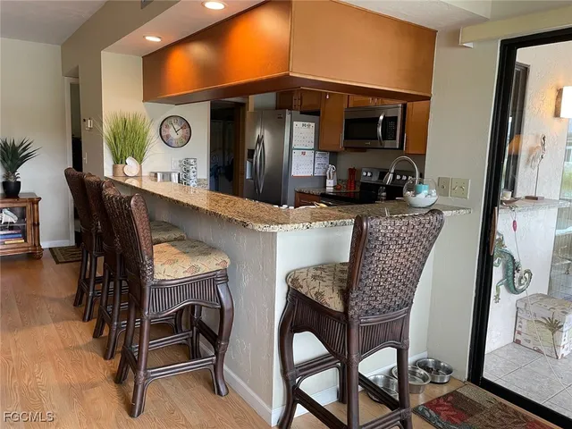 a kitchen with stainless steel appliances granite countertop a sink a stove and a refrigerator