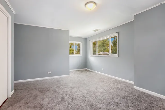 an empty room with windows and closet