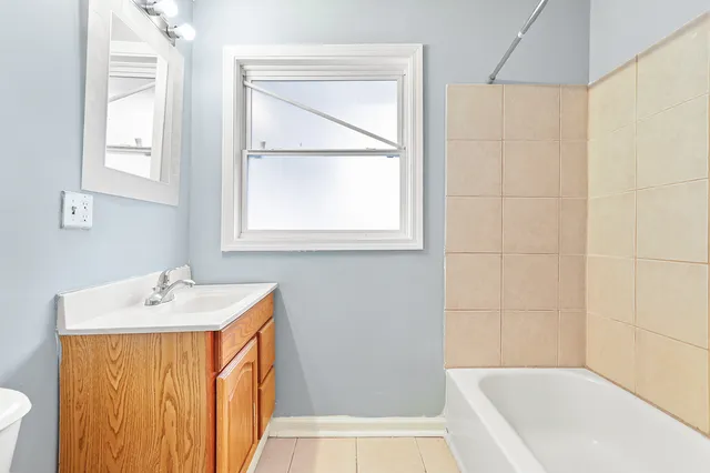 a bathroom with a sink a bath tub and a window