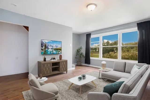 a living room with furniture a large window and a flat screen tv