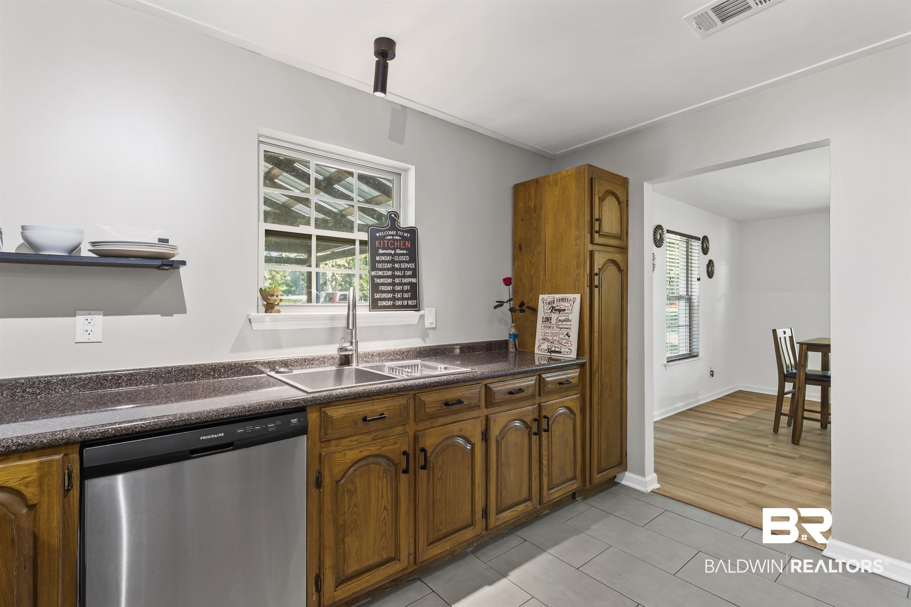 8911 Owassa Road Evergreen, AL 36401 - Photo 5 of 24 Kitchen featuring dark countertops, dishwasher, healthy amount of natural light, and light tile patterned flooring