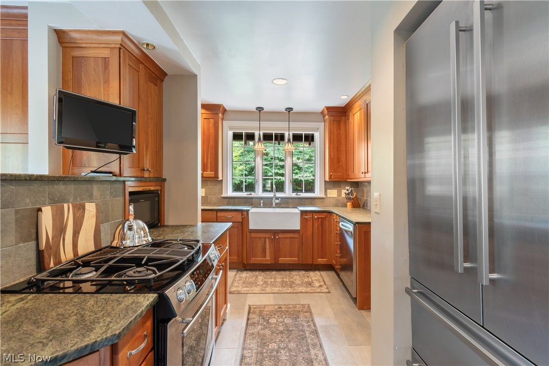 407 Merriman Road Akron, OH 44303 - Photo 12 of 37 Kitchen with pendant lighting, stainless steel appliances, sink, tasteful backsplash, and dark stone counters