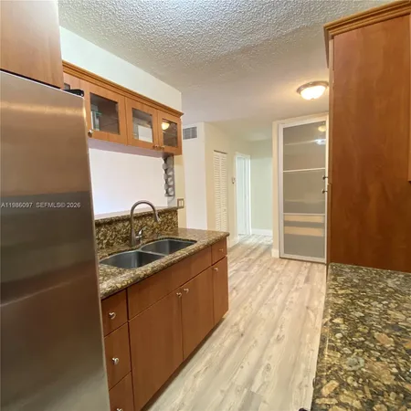 a kitchen with granite countertop a sink and a stove