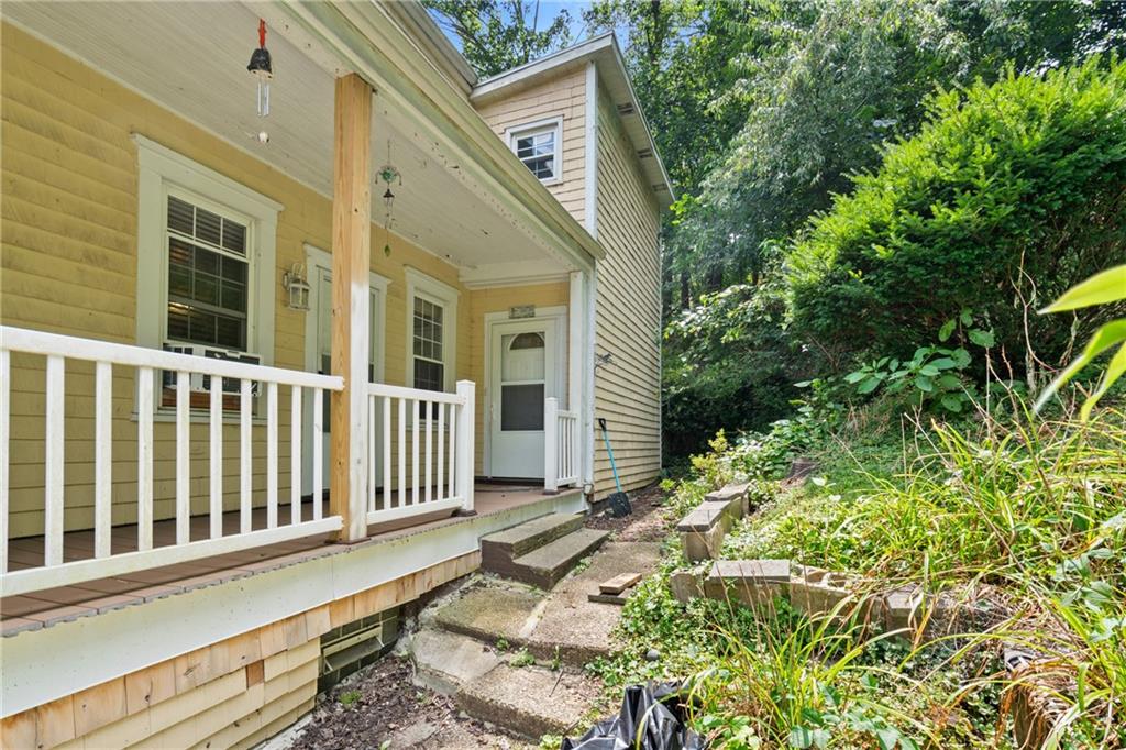 223 Hickory Street McKees Rocks, PA 15136 - Photo 3 of 27 a view of a house with a small yard and floor to ceiling window and wooden fence