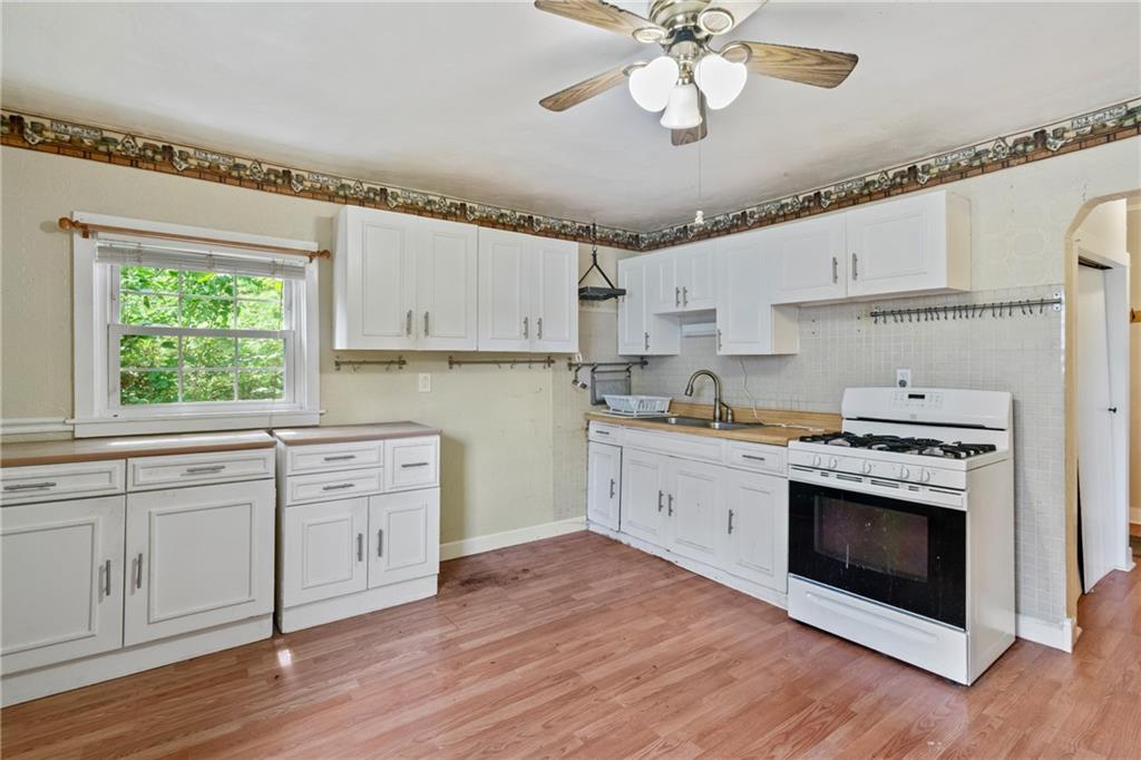 223 Hickory Street McKees Rocks, PA 15136 - Photo 9 of 27 a kitchen with cabinets wooden floor and a stove