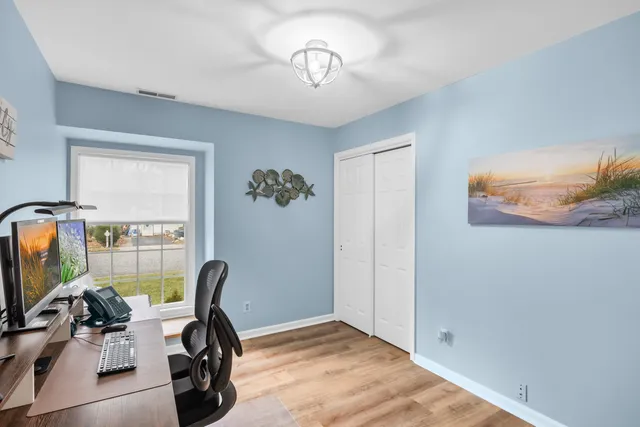 a view of a workspace with furniture and a window