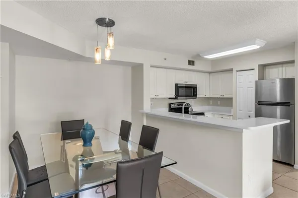 a view of kitchen with cabinets table and chairs