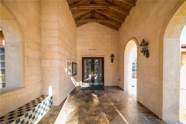 a view of a hallway with wooden floor and a living room