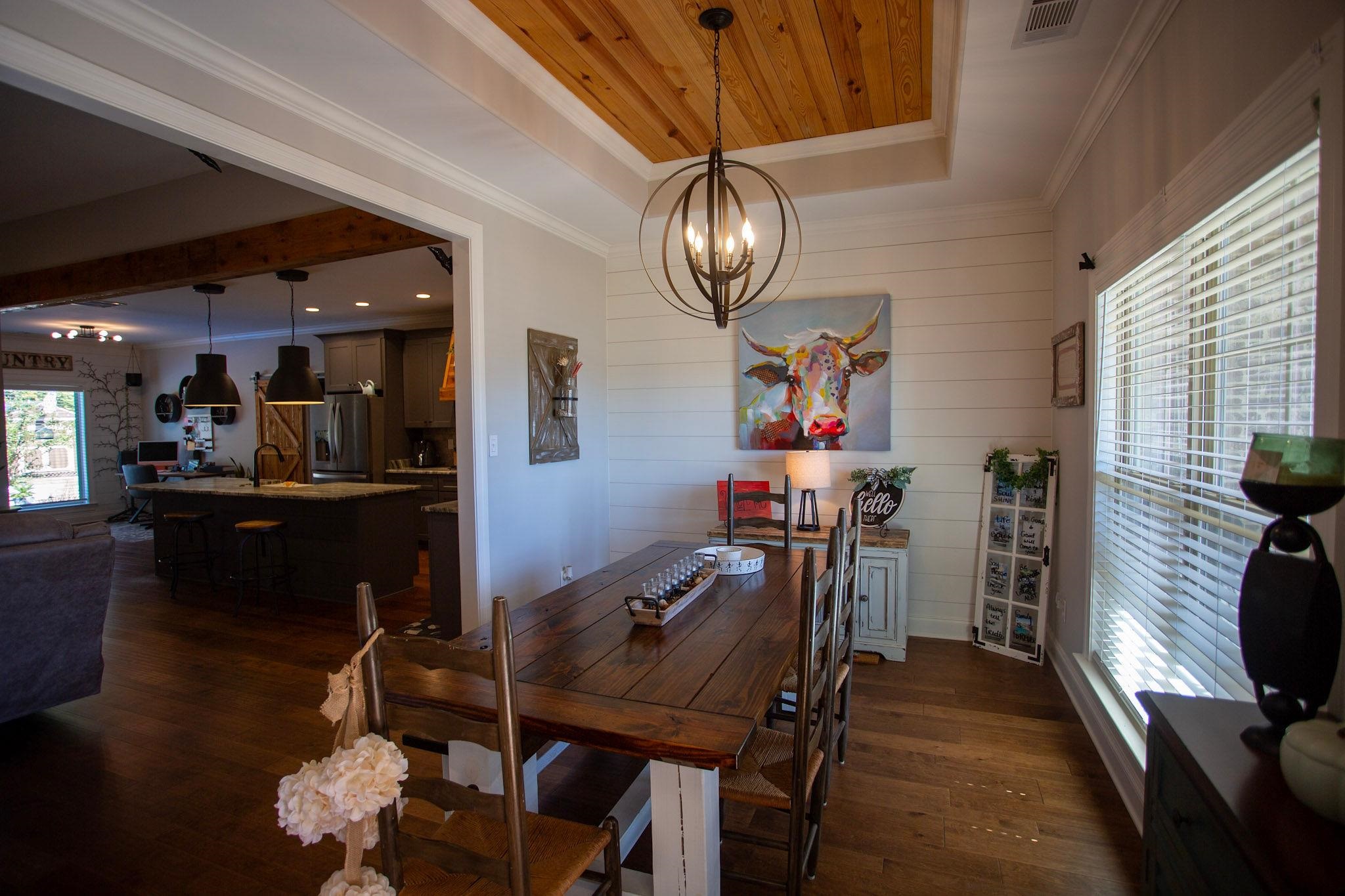 22 Cedar Ridge Cove Atoka, TN 38004 - Photo 6 of 39 Dining area featuring a chandelier, a tray ceiling, dark wood-type flooring, crown molding, and sink