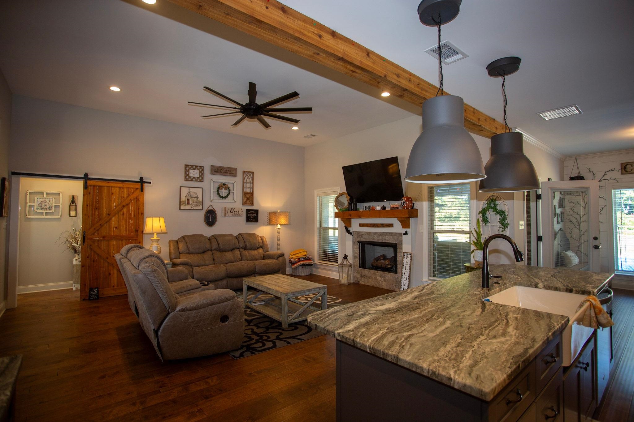 22 Cedar Ridge Cove Atoka, TN 38004 - Photo 8 of 39 Living room featuring beamed ceiling, dark wood-type flooring, sink, a barn door, and ceiling fan