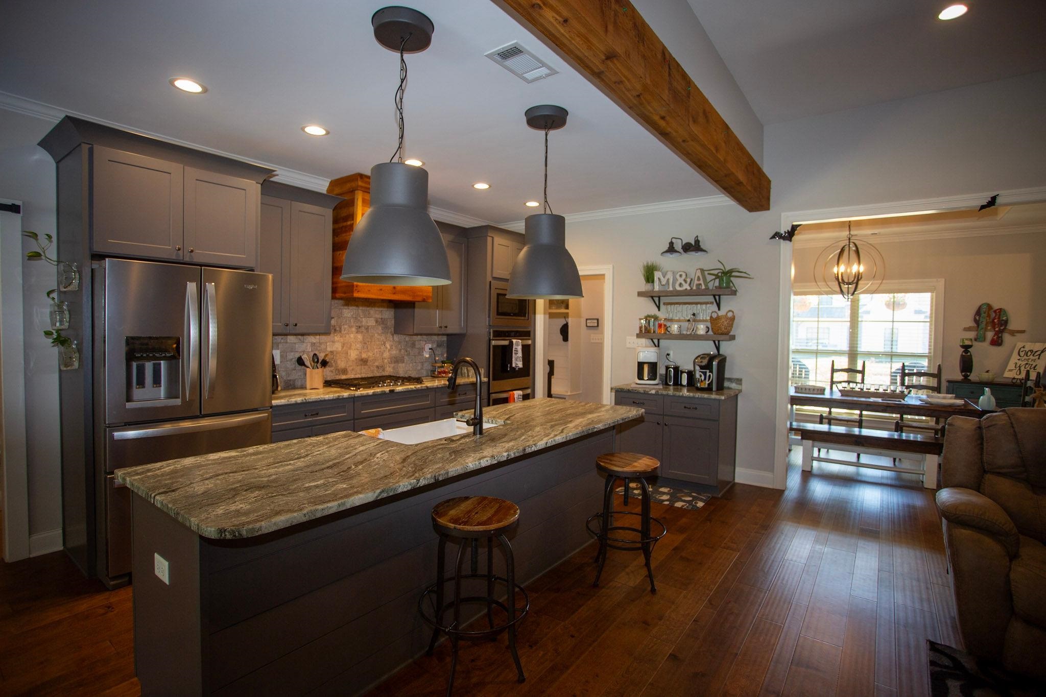 22 Cedar Ridge Cove Atoka, TN 38004 - Photo 10 of 39 Kitchen with beam ceiling, dark hardwood / wood-style flooring, appliances with stainless steel finishes, gray cabinets, and light stone counters