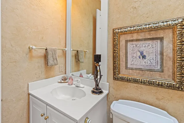 a view of a house with a small yard and large trees