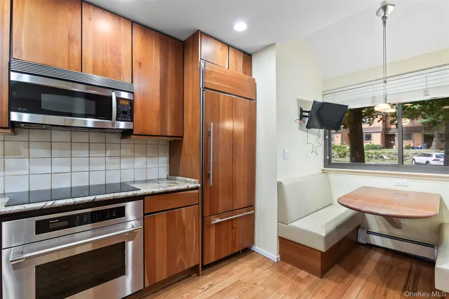 a kitchen with a refrigerator an oven a sink and dishwasher with wooden floor