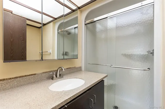 a bathroom with a granite countertop sink toilet and a mirror