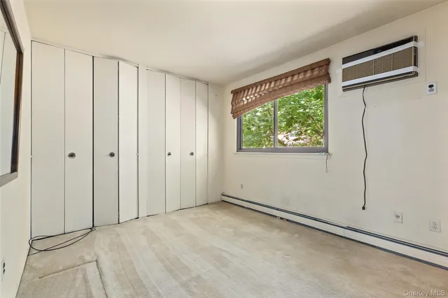 a view of an empty room with wooden floor and windows