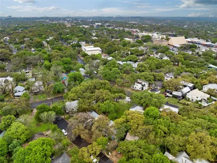 an aerial view of residential houses with outdoor space and trees
