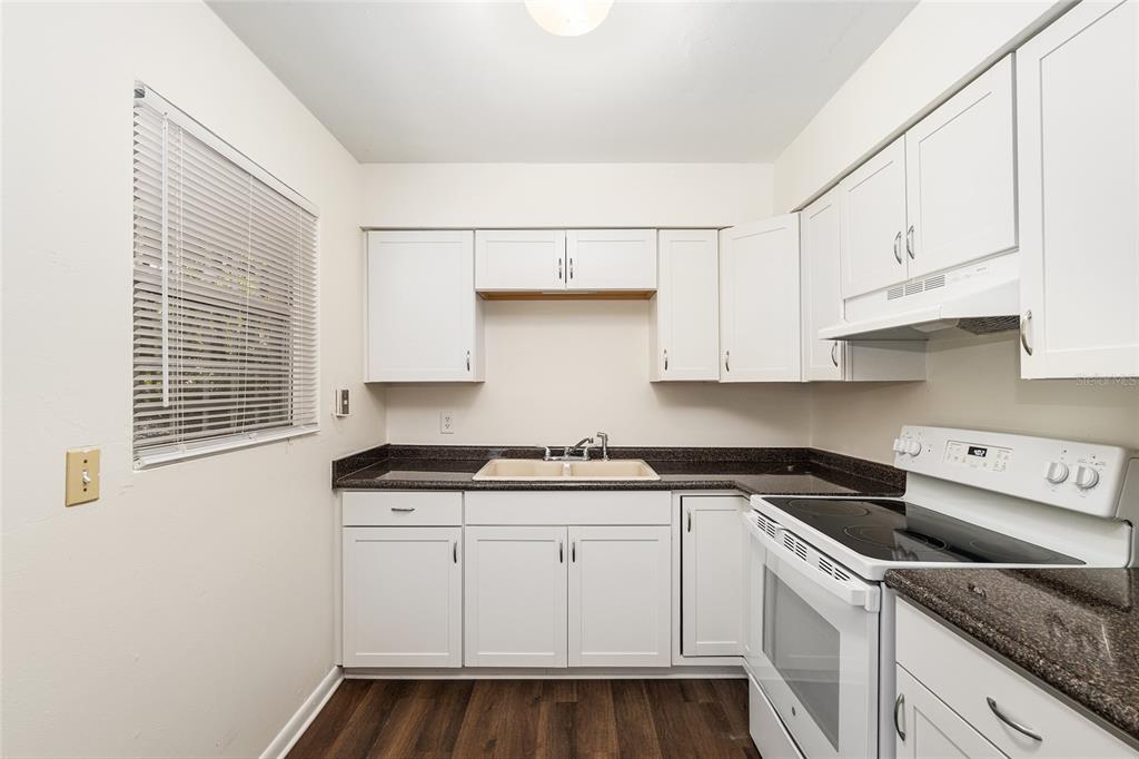 2511 Northeast 3rd Place Gainesville, FL 32641 - Photo 11 of 29 a kitchen with granite countertop white cabinets and white appliances