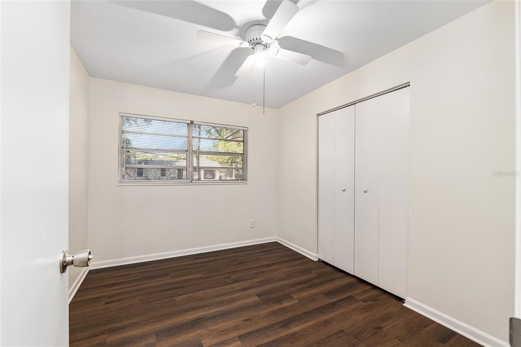 2511 Northeast 3rd Place Gainesville, FL 32641 - Photo 13 of 29 an empty room with wooden floor chandelier fan and windows