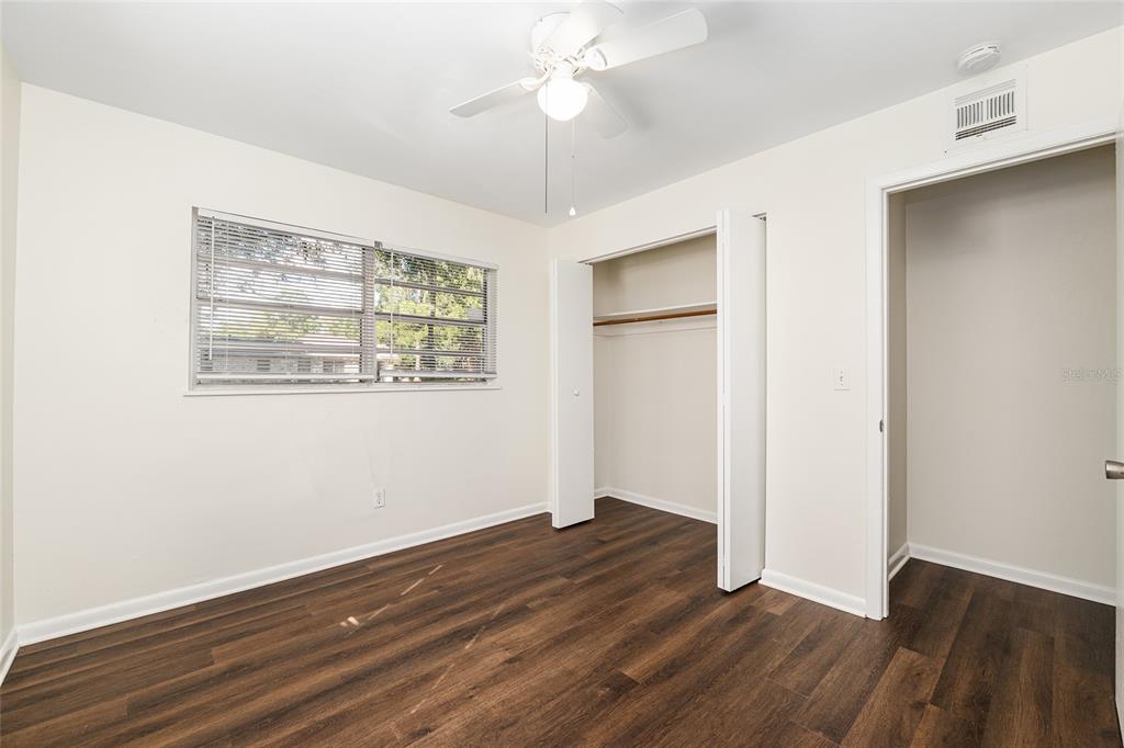 2511 Northeast 3rd Place Gainesville, FL 32641 - Photo 16 of 29 an empty room with wooden floor chandelier fan and windows