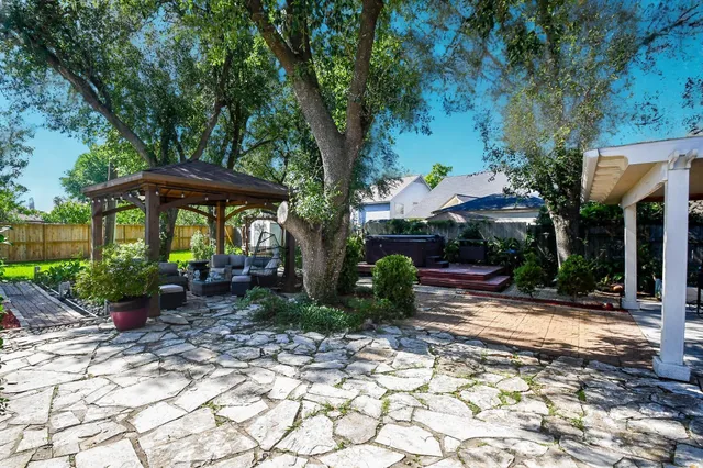 a view of a patio with furniture and a table and chairs under an umbrella