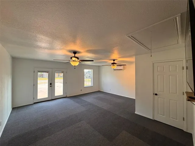 a view of a big room with windows and chandelier fan