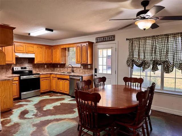 a kitchen with a dining table chairs and refrigerator