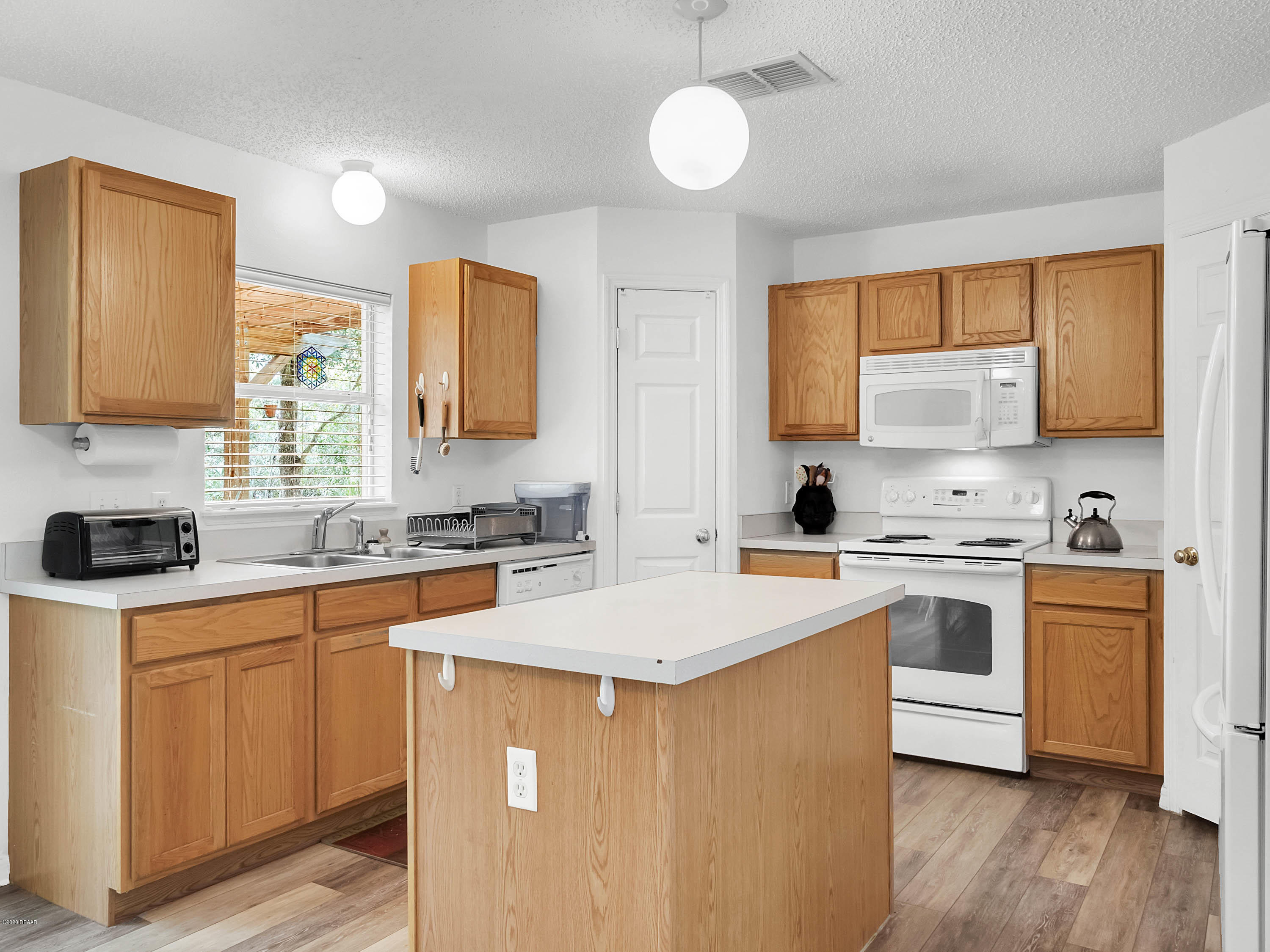 1982 7th Avenue DeLand, FL 32724 - Photo 9 of 36 a kitchen with stainless steel appliances granite countertop a stove top oven a sink dishwasher and white cabinets with wooden floor